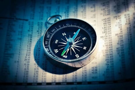 Compass on top of a stock market report