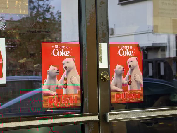 Coca-Cola's 'Share a Coke' campaign poster represents storytelling in content marketing that connects with people.