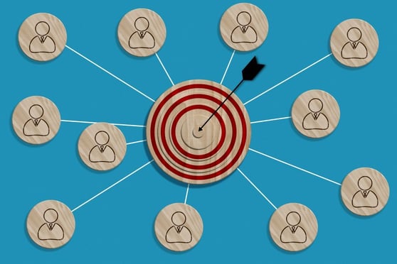 A wooden round target with an arrow and wooden plaques.